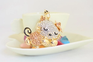 Detailed macro view of gold-plated sleeping cat keychain with sparkling rhinestones