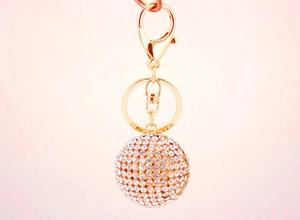 Detailed view of a golden rhinestone crystal ball keychain with lobster clasp and ring