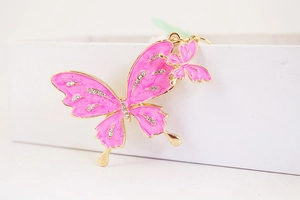 Detailed view of pink enamel butterfly keychain with crystal rhinestones on gold metal