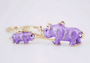Vue détaillée de breloques rhinocéros mère et enfant en émail violet avec strass blancs