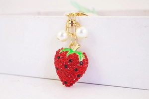 Close-up of strawberry keychain with red rhinestones, green leaves and white pearls