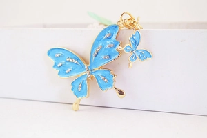 Close-up of sky blue enamel butterfly keychain with crystal rhinestones on gold alloy