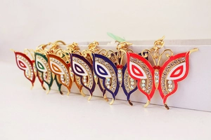 Close-up of colorful rhinestone butterfly keychains with gold-plated alloy and enamel detail