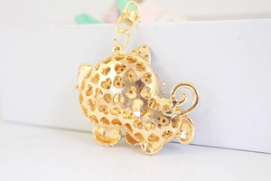 Detail of gold-plated cat keychain featuring intricate heart-shaped hollow-out design
