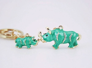 Gros plan sur les porte-clés rhinocéros en émail vert avec cristaux et anneau doré