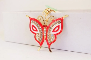 Detail of butterfly keychain with red and white enamel and sparkling rhinestones