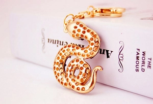 Detailed view of a golden rhinestone snake keychain with alloy texture and lobster clasp