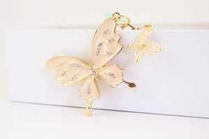 Close-up of pink enamel butterfly keychain featuring sparkling rhinestones and gold plating