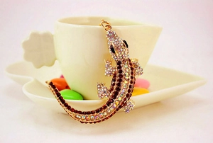 Detail of lizard keychain featuring sparkling rhinestones on a polished gold metal base