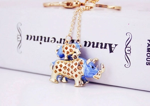 Détail du porte-clés rhinocéros en émail bleu avec des motifs floraux dorés ajourés