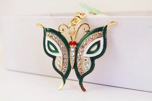 Detailed close-up of butterfly keychain featuring green enamel and sparkling rhinestones