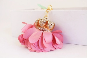 Macro detail of the pink fabric flower petals and rhinestone gold crown keychain