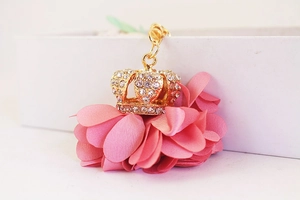 Macro view of gold crown keychain with pink fabric petals and sparkling rhinestones