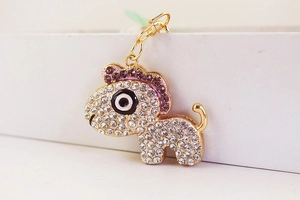 Détail d'un porte-clés cheval mignon orné de strass brillants blancs et violets