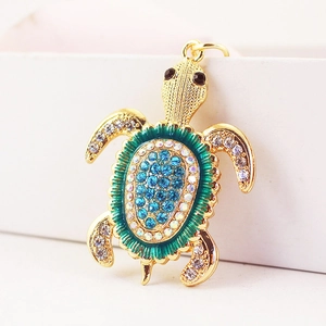 Porte-clés tortue dorée avec strass bleus brillants et détails en émail vert élégant