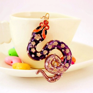 Deep purple enamel snake keychain with gold floral patterns and sparkling rhinestones