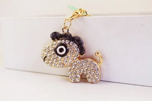Gros plan du porte-clés doré orné de strass brillants et de détails en émail