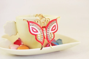 Close-up of colorful rhinestone butterfly keychain with red and white enamel finish