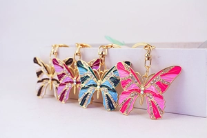 Close-up of sparkling rhinestone butterfly keychains in various colorful enamel finishes