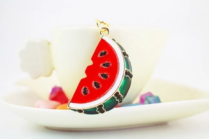 Detail of creative watermelon slice keychain with red enamel and black rhinestones