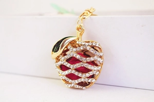 Detailed macro view of an apple keychain with sparkling rhinestones and golden hollow design