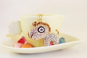 Vue détaillée du pendentif poney incrusté de strass accroché à une tasse en porcelaine
