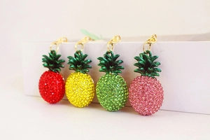 Macro view of crystal pineapple keychains in four vibrant colors with gold lobster clasps