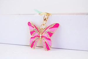 Detailed close-up of butterfly keychain with pink enamel inlay and sparkling rhinestones