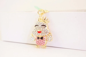 Dettaglio macro del portachiavi pulcino con corona con strass rosa e chiusura dorata