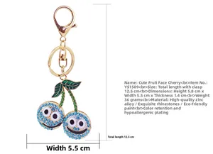 Porte-clés cerise en strass bleus avec visage souriant et fermoir doré chic