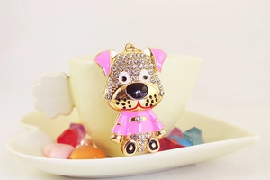 Détail d'un porte-clés chien tacheté avec émail rose et strass sur une tasse de café