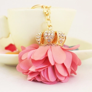 Elegant pink fabric flower keychain with a gold rhinestone crown and metal clasp