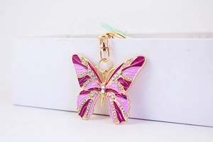 Macro shot of purple enamel butterfly keychain with crystal rhinestones on a gold alloy base