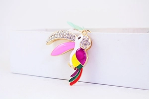 Macro shot of colorful rhinestone toucan charm with vibrant enamel paint and gold metal base