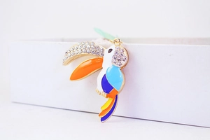 Close-up of a vibrant parrot keychain featuring colorful enamel and sparkling rhinestones
