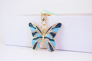 Close-up of blue rhinestone butterfly keychain with enamel inlay and gold-tone lobster clasp