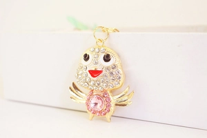 Macro view of gold plated chick keychain with pink rhinestones and white crystal head