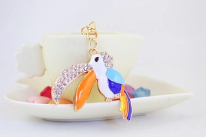 Detail of colorful enamel toucan keychain with sparkling rhinestones and gold finish