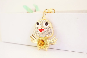Detailed close-up of a crystal bird keychain with amber gemstone and gold plating