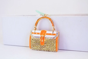 Nahaufnahme von Mini-Handtaschen-Schlüsselanhänger mit Emaille und glitzernden Steinen