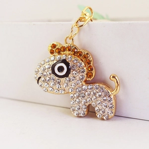 Cute golden animal keychain pendant with white and amber rhinestones on white background