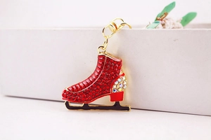 Macro shot of red rhinestone skate keychain with gold plating and black blade detail