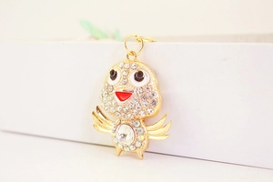 Close-up of cute crystal bird keychain with sparkling rhinestones and golden metal details