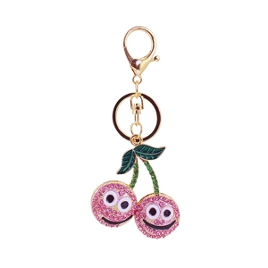 Porte-clés cerise en strass roses avec anneau doré et visage souriant