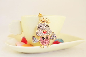 Dettaglio del portachiavi a pulcino dorato con strass rosa e ciondolo a corona
