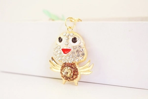 Detail of creative chicken keychain with sparkling crystals and champagne rhinestone center