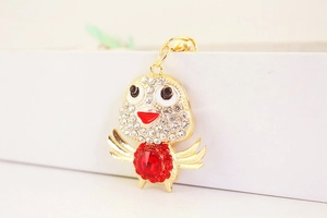 Detail showing the intricate gold-plated alloy bird charm with vibrant red zircon crystals