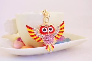 Detailansicht eines bunten Eulen-Schlüsselanhängers mit Strass an einer Teetasse
