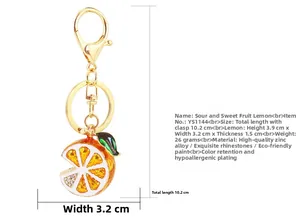 Detail showing dimension and materials of lemon keychain with yellow enamel and rhinestones