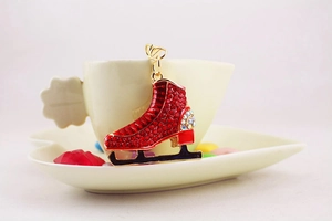 Close-up of red rhinestone ice skate keychain hanging on a white coffee cup